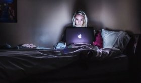 person in bed with laptop