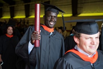 Norwich grad smiling with diploma