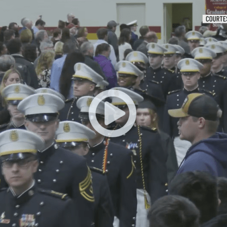 A group of cadets stand in uniform while in line at an event.