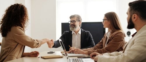 Four business professionals sit in a meeting