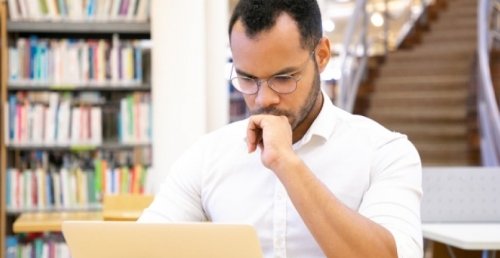student works on history thesis in university library