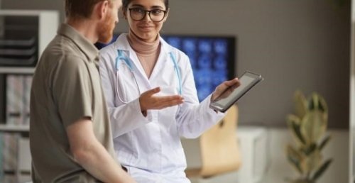 a nurse holding a tablet is discussing test results with a patient