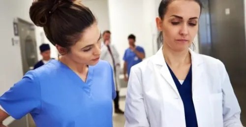 nurse manager reviews medical records with a nurse