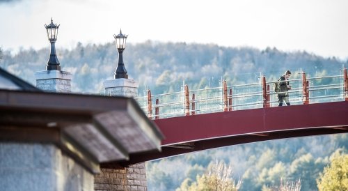 Norwich student walking over a bridge on campus