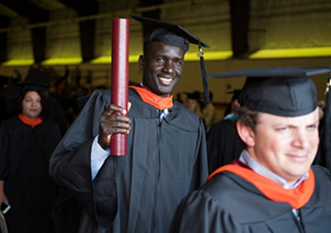 Norwich grad smiling with diploma