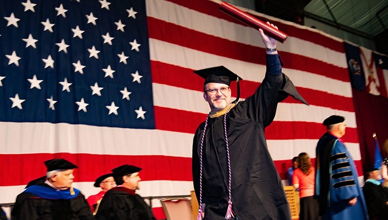 a student crosses the stage at commencement