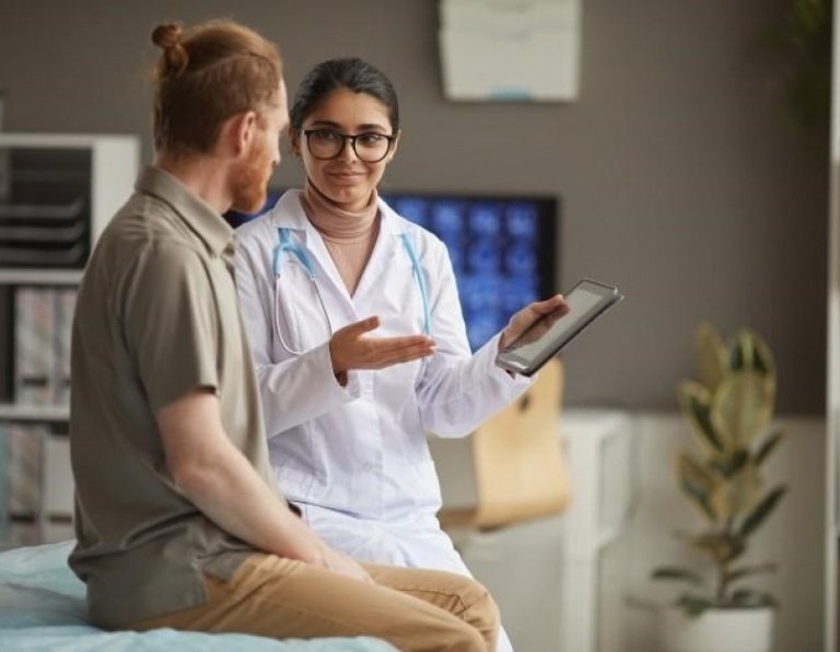 a nurse holding a tablet is discussing test results with a patient