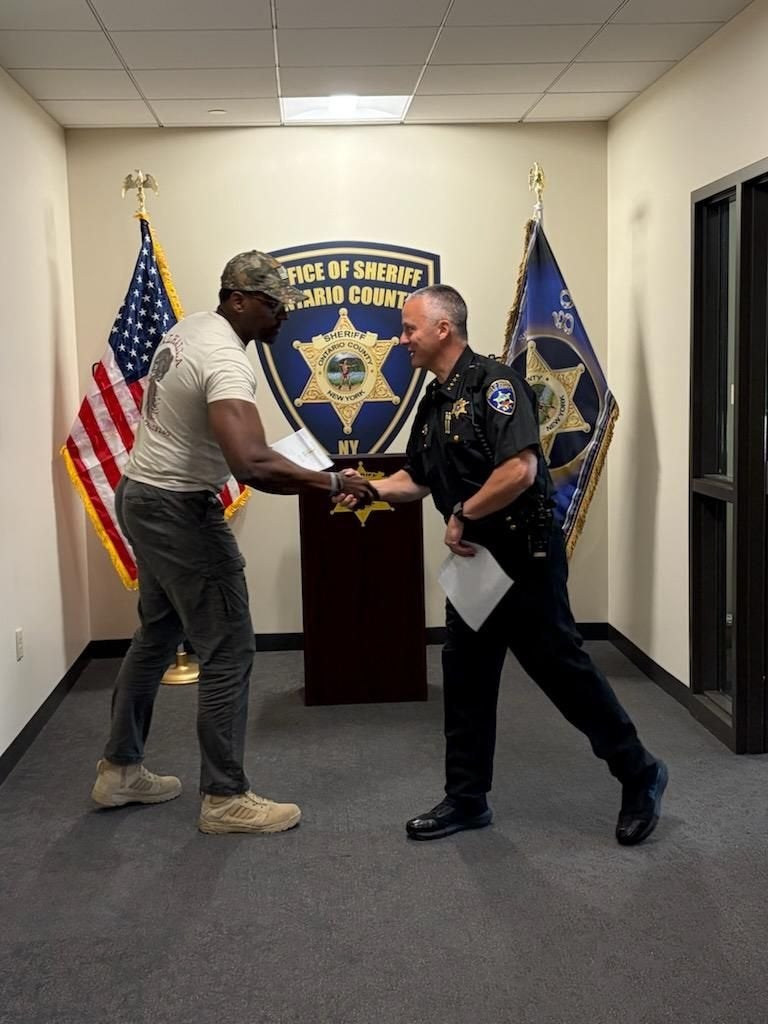 sim shaking ontario county sheriff hand