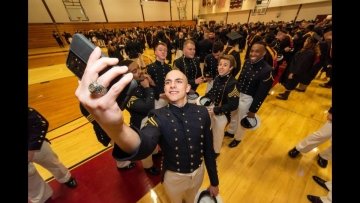 A graduating cadet grabs a last selfie with his friends as they prepare to march down for commencement.