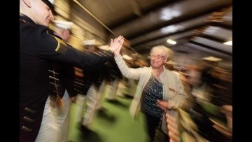 Jane Lane, admin for the David Crawford School of Engineering shares a hi-5 with a graduating student as he marches into Shapiro Fieldhouse for the 2022 graduation.